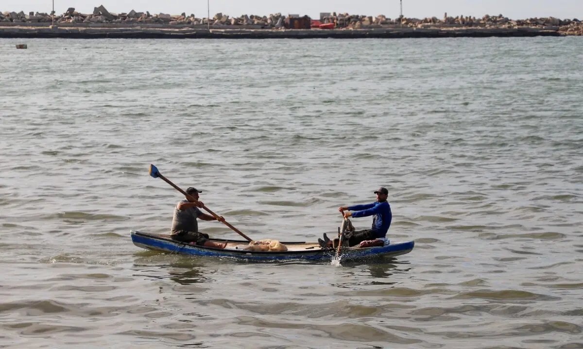 Gazan fishermen patch up dinghies with door frames to keep themselves afloat